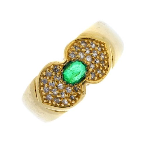 An emerald and diamond ring. The oval-shape emerald, with pave-set diamond sides, to the plain band.
