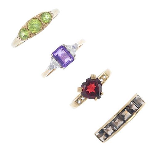 Four 9ct gold gem-set rings. To include a circular-shape peridot three-stone ring, a square-shape sm