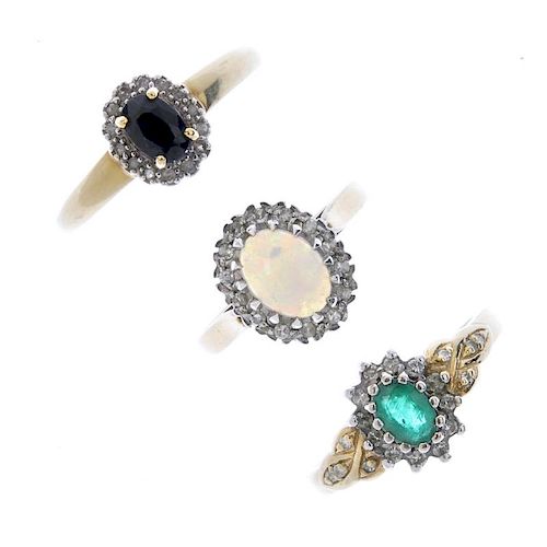 A selection of three 9ct gold diamond and gem-set cluster rings. Each set with an oval-shape emerald