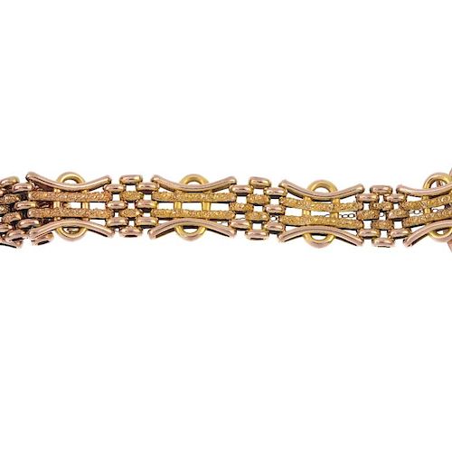 An early 20th century 9ct gold gate bracelet. Designed as a series of textured and plain four-bar li