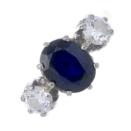 A sapphire and diamond three-stone ring. The oval-shape sapphire, with brilliant-cut diamond shoulde