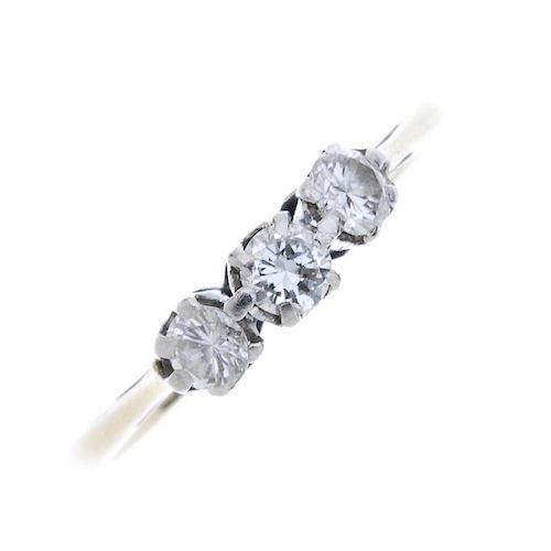 A diamond three-stone ring. The brilliant-cut diamond line, to the plain band. Estimated total diamo