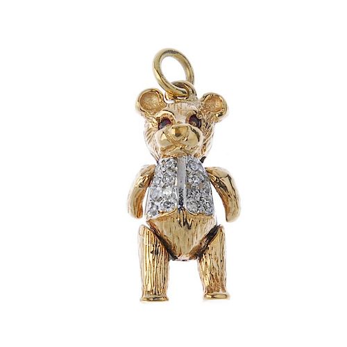 A 9ct gold ruby and diamond bear pendant. Of textured design, the articulated bear, with single-cut