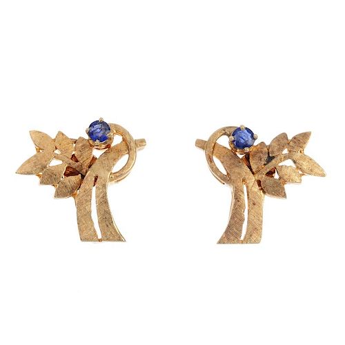 A pair of sapphire earrings. Each of foliate design, the textured branch, with circular-shape sapphi