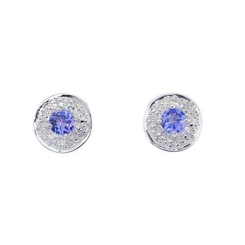 A pair of 9ct gold tanzanite and diamond ear studs. The circular-shape tanzanite, within an illusion