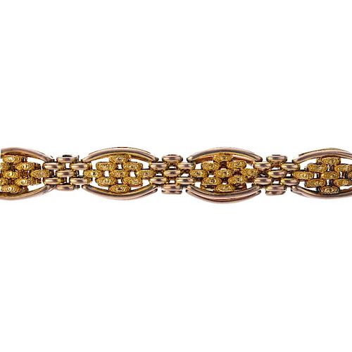 An early 20th century 9ct gold bracelet. Designed as a series of textured brick-link panels, with po