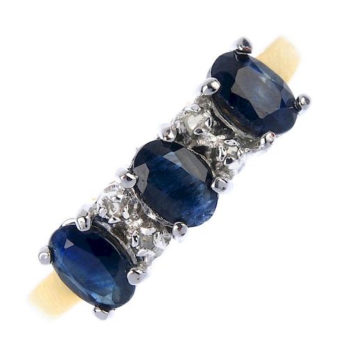 A sapphire three-stone and diamond accent ring. The oval-shape sapphire line, with diamond double sp