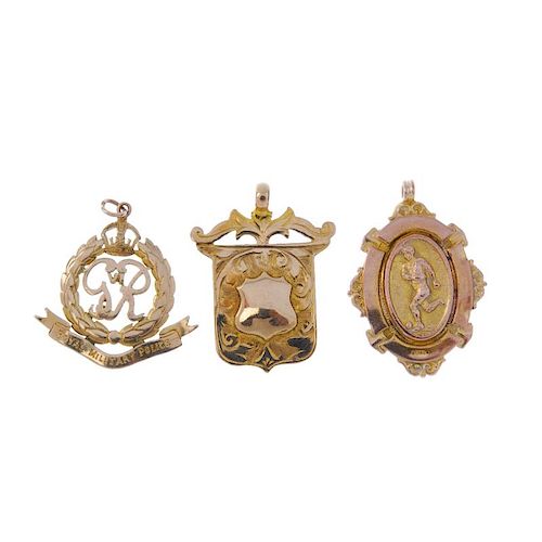 Three early 20th century 9ct gold pendants. To include a royal military police pendant, an engraved