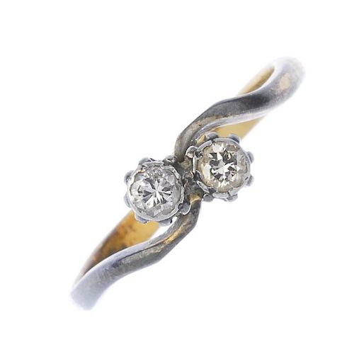 A mid 20th century 18ct gold diamond two-stone crossover ring. The brilliant-cut diamond diagonal li