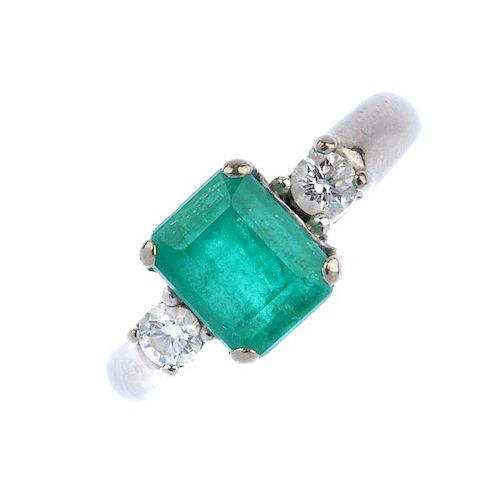 (536613-3-A) An 18ct gold emerald and diamond three-stone ring. The rectangular-shape emerald, with