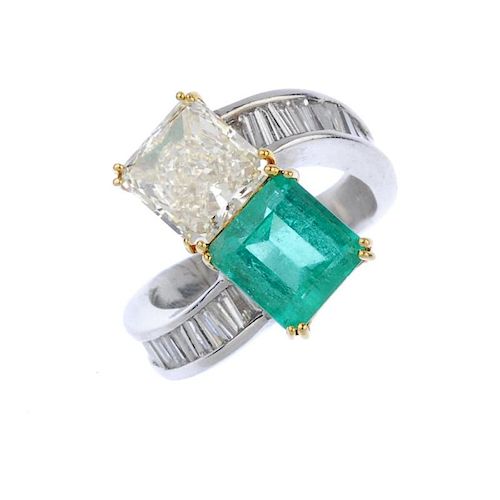 (540113-1-A) A diamond and emerald two-stone crossover ring. The square-shape diamond and similarly-