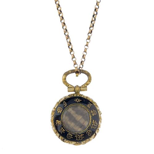 A late 19th century enamel memorial locket and 9ct gold chain. Of circular outline, the glazed woven