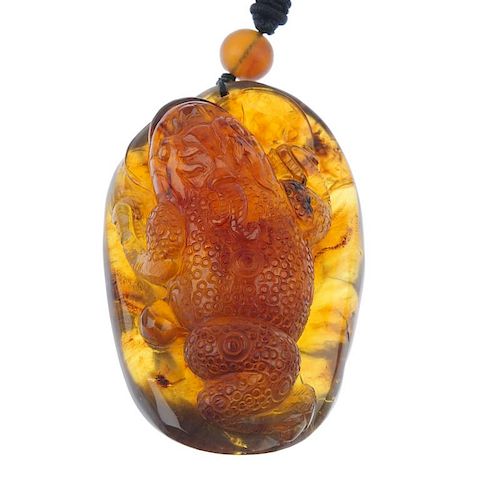 A natural Burmese brown/red amber carved pendant. Carved to depict Jin Chan, commonly known as the M