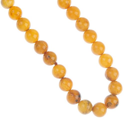 A natural amber necklace. Comprising thirty-nine spherical beads, measuring 1.8cms. Length 66cms. We