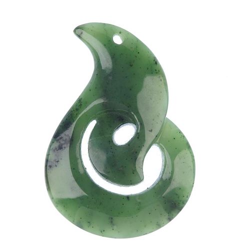 A carved Maori jade koru pendant. The koru representing an unfurling fern leaf and symbolising new b