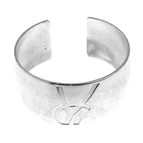 YVES SAINT LAURENT - a cuff bangle. The cuff with embossed YSL logo half visible to the front. Impor