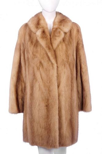 A three-quarter length pastel mink coat. Designed with a notched lapel collar, hook and eye clip fas