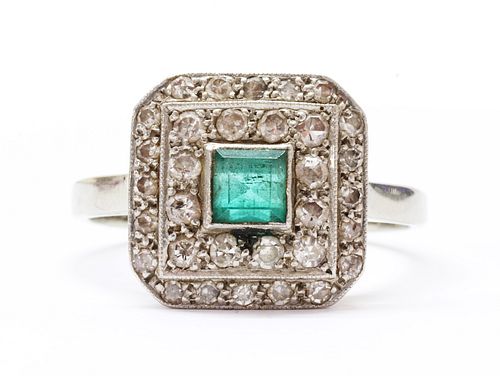 A white gold emerald and diamond cluster ring,