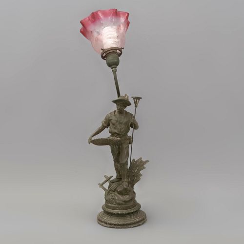 Lámpara de mesa. Origen europeo, sXX. Estilo Art Nouveau. Elaborada en antimonio. Con pantalla de vidrio en forma de flor.