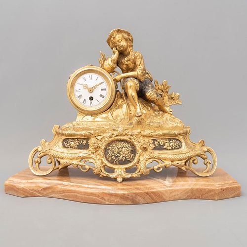 Reloj de chimenea. Alemania, sXX. Elaborado en bronce dorado. Con base de ónix. Con carátula blanca e índices romanos.