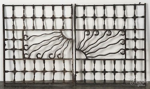 Pair of decorative cast iron window grates with a central sun motif, 27 1/2'' x 24''