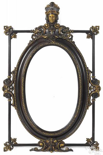 Paint and gilt decorated cast iron mirror, late 19th c., with a figural crest, 39 1/2'' x 24 3/4''.