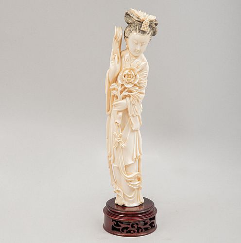Quan Yin. Origen oriental, SXX. Talla de marfil con detalles en tinta negra. Base de madera. 26 cm de altura.