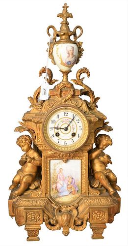 French Style Figural Mantle Clock, having two putti forms, painted urn finial and porcelain plaque, height 22 1/2 inches, width 11 inches, depth 7 inc