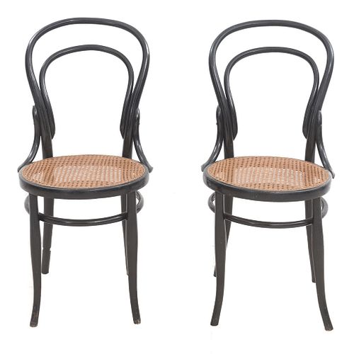 Par de sillas. SXX. Estilo Austriaco. Elaboradas en madera color negra. Respaldos semiabiertos, asientos de bejuco tejido.