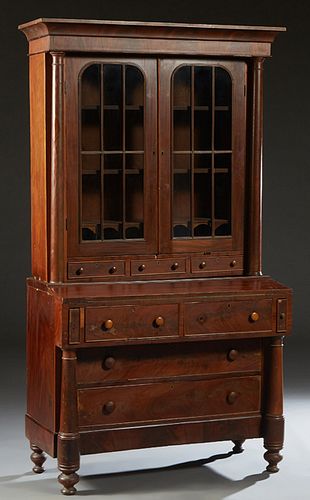 American Carved Mahogany Secretary Bookcase, 19th c., the ogee crown over double arched mullioned glazed doors, over two shallow drawers, flanked by t