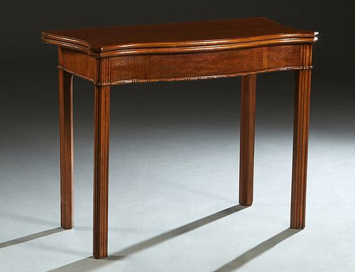 English Chippendale Style Carved Mahogany Games Table, early 20th c., the serpentine canted corner top with an inset gilt tooled green leather gaming 