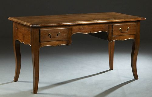 French Provincial Louis XV Style Carved Walnut Writing Table, late 19th c., the stepped edge rectangular top over a central scalloped skirt, flanked b