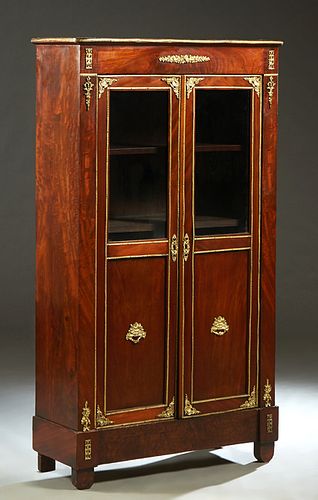 French Ormolu Mounted Carved Walnut Louis XVI Style Bookcase, early 20th c., the rounded corner top over double doors with glazed upper panels above w