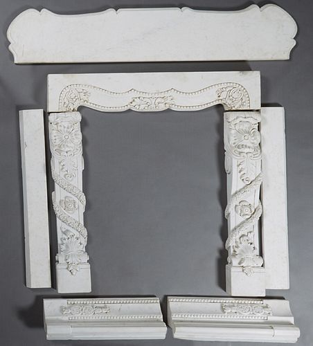 Carved White Marble Fireplace Mantel, late 19th c., the ogee edge serpentine top above a thick serpentine skirt, flanked by floral and garland carved 
