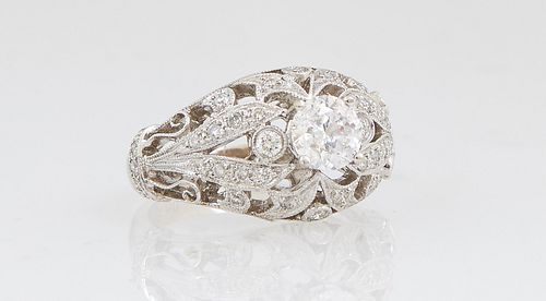 Lady's 18K White Gold Dinner Ring, with a central round .71 carat diamond, flanked by two small round diamonds and a pierced diamond mounted top and s