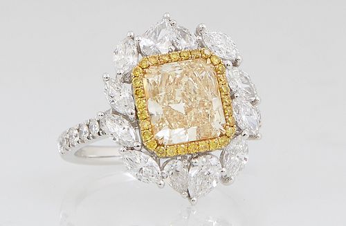 Lady's 18K White Gold Dinner Ring, with a 2 carat fancy yellow rectangular cut diamond, within a border of thirty tiny round yellow diamonds, atop a b