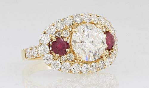 Lady's 18K Yellow Gold Dinner Ring, with a central 2.9 carat round diamond, flanked by two round rubies, within an oval border of round white diamonds