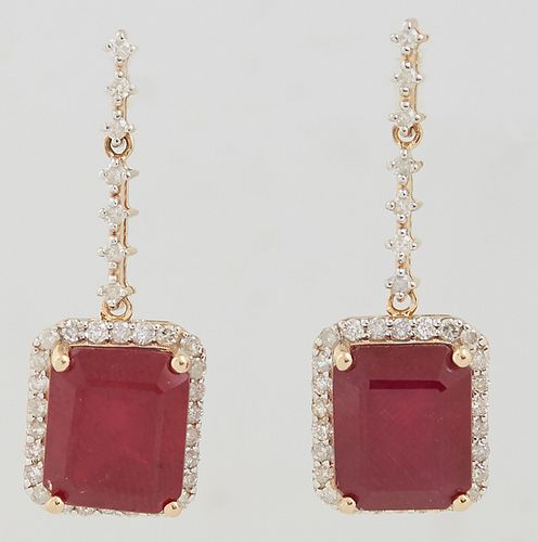 Pair of 14K Yellow Gold Earrings, with a diamond mounted stud to a diamond mounted chain, suspending an emerald cut ruby, atop a border of tiny round 