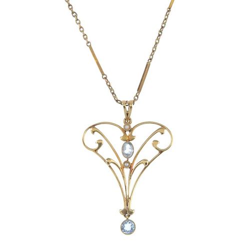 An early 20th century 15ct gold gem-set pendant and 9ct gold chain. The scrolling foliate openwork p