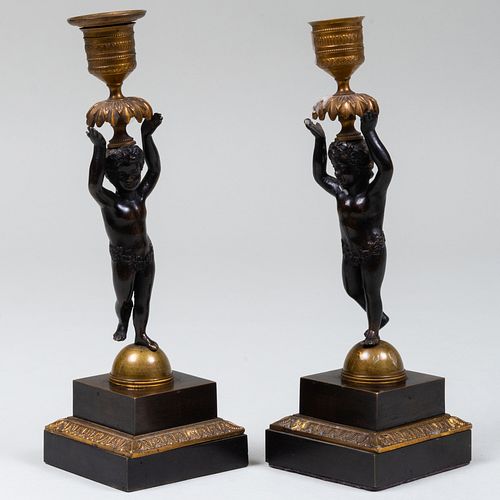 Pair of Patinated Metal Candlesticks with Putti Supports