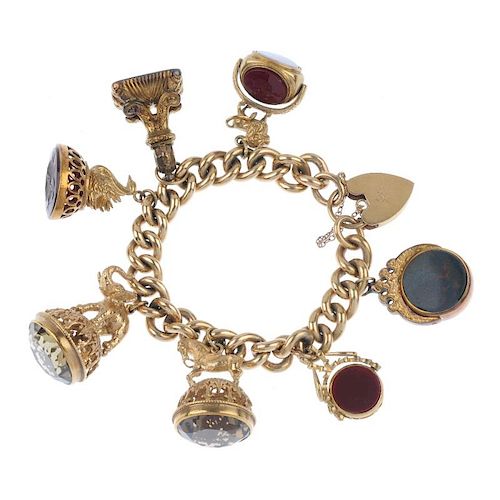 A 9ct gold charm bracelet. Designed as a series of seven gem-set fobs, to include an elephant fob wi