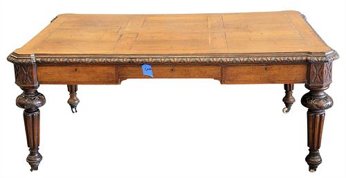 Oak Library Table/Desk, having carved frame set on fluted legs and casters, height 29 inches, top 45" x 68".