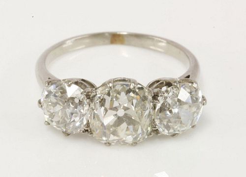 A three stone diamond ring,with a cushion cut diamond