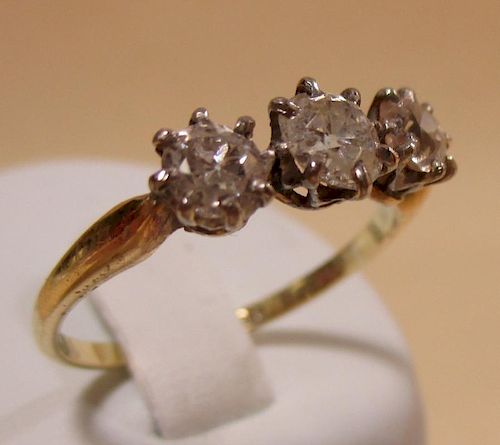 A three stone diamond ring, the three slightly graduated round brilliant cut diamonds all claw set i
