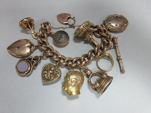 A charm bracelet with heart locket clasp and eleven pendant charms, the chunky curb link bracelet of