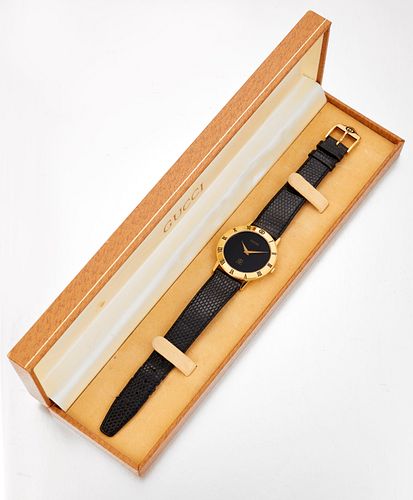 A GENTLEMAN'S GOLD-PLATED GUCCI STRAP WATCH,?circular black dial with gilt 