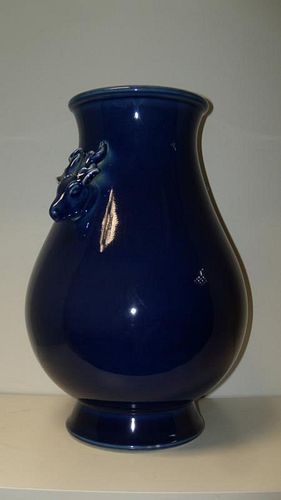 A 20th century blue glazed vase, the shoulders of the ovoid shape flaring up to the rims and applied