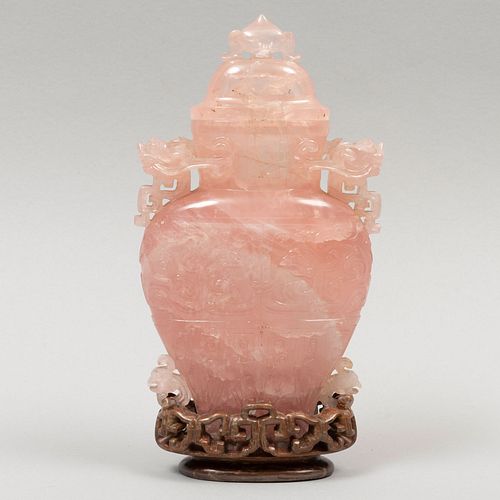 Ánfora. China, SXX. Talla de cuarzo rosa, con base de madera. Decorado con motivos orgánicos. 17 cm de altura.