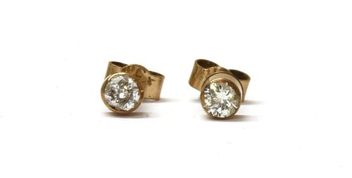 A pair of gold single stone diamond earrings,