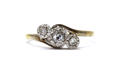 A gold three stone diamond crossover ring,